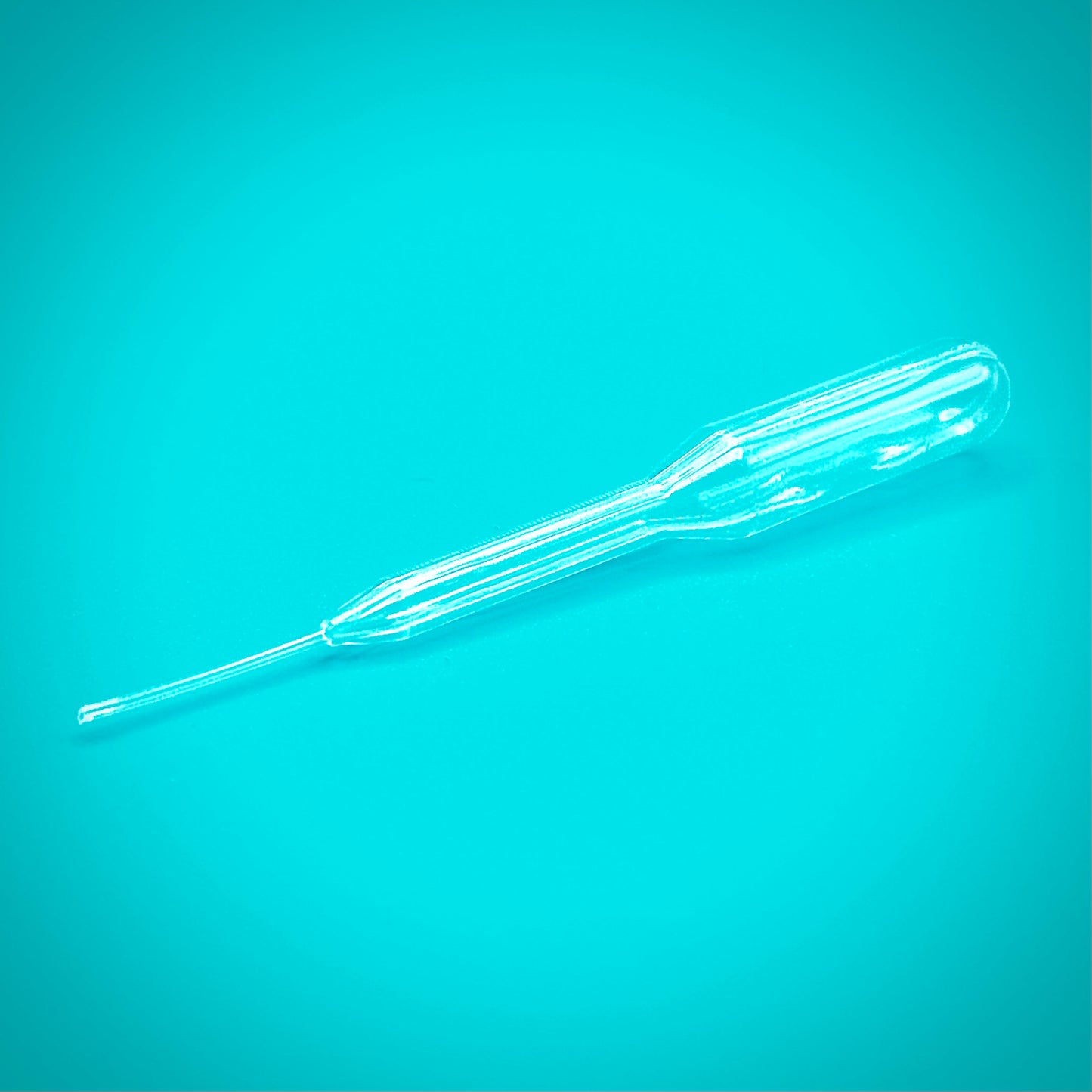 Close-up image of a transparent pipette for essential oils against a blue background, designed for precision oil application